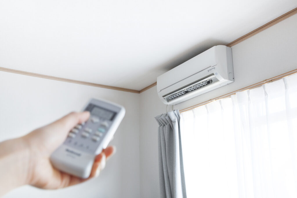 Person using remote to adjust temperature on a mini split system in their home 